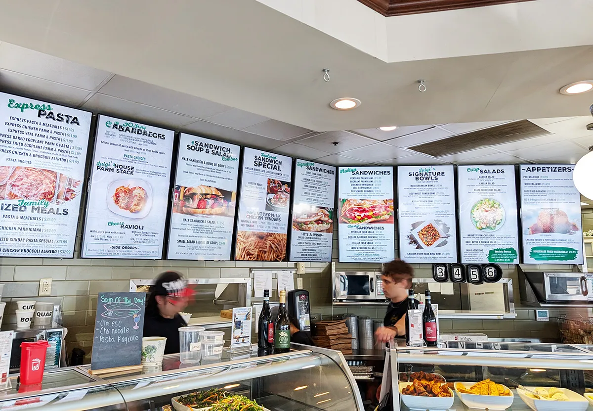 Digital menu boards above the counter at Luigi's Gourmet