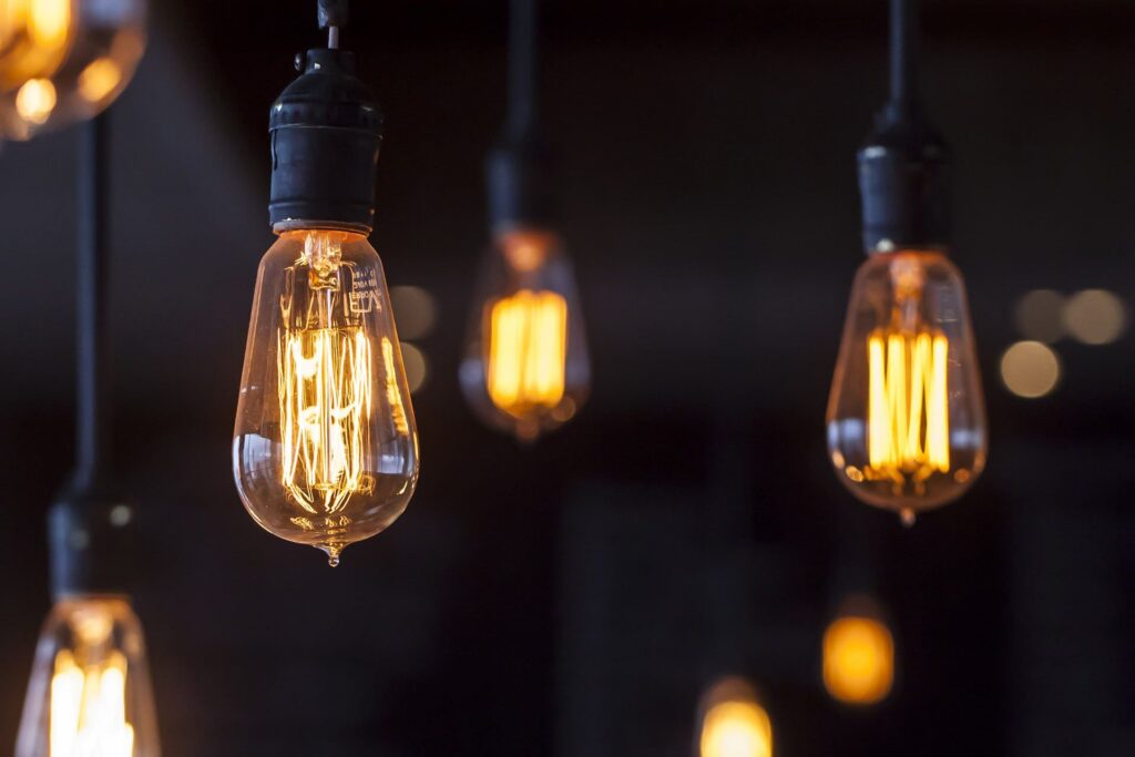 Vintage Edison bulbs cast a warm glow in a modern workspace, sparking creativity for marketing and web design innovation.
